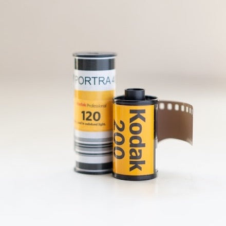 Rolls of Kodak Portra 120 and Kodak Gold 35mm film standing side by side