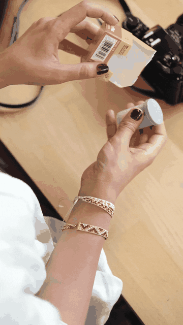 Hands removing a 35mm film canister from its box and loading the film into a camera